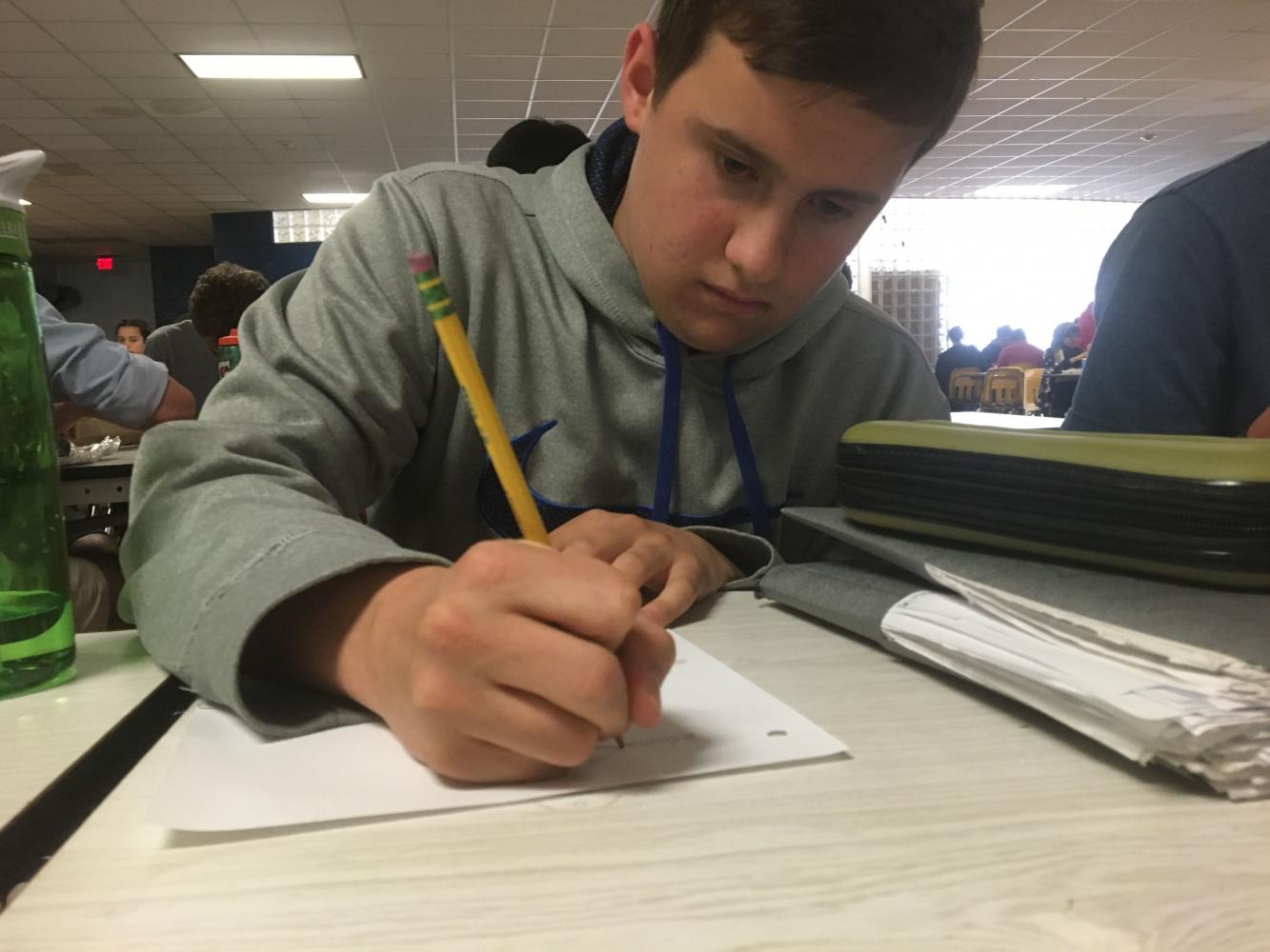 Sophomore John Beckman, founder of the community service club, works on making a poster for his club to inform others of what the community service club is all about.
