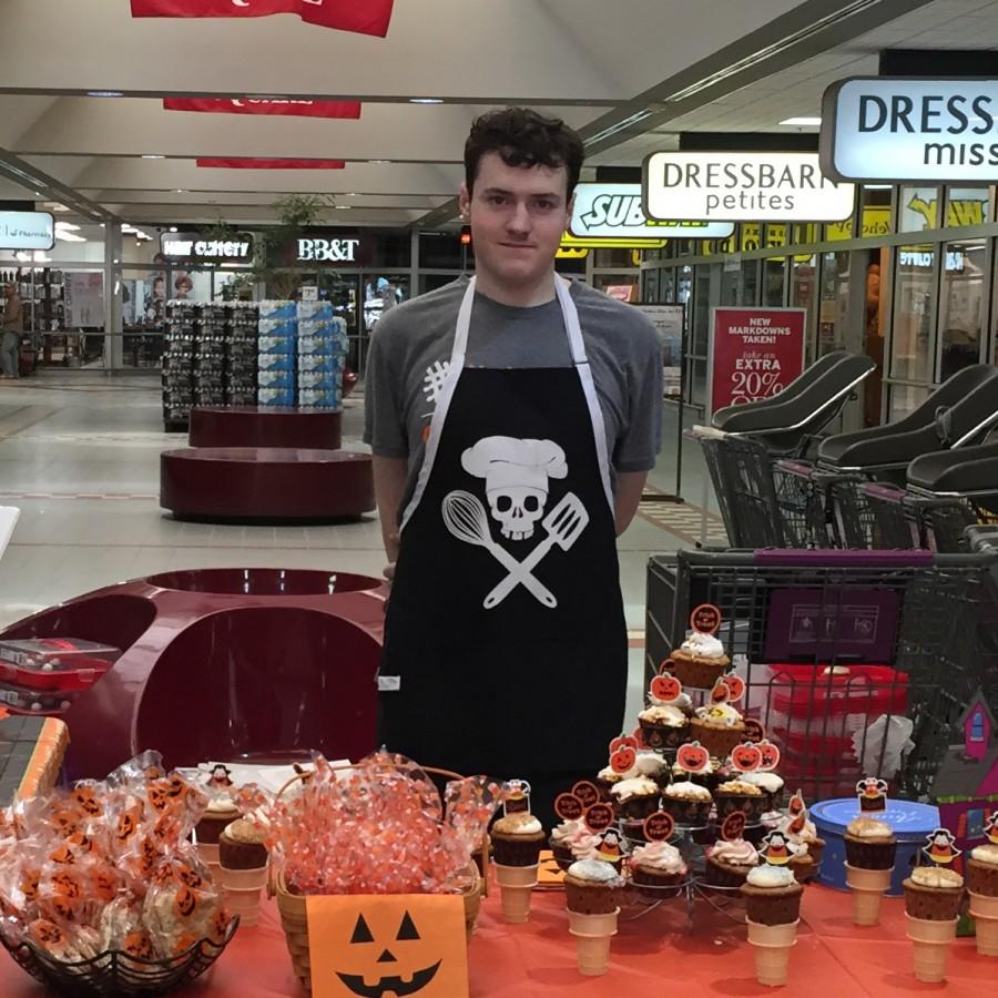 Senior Kevin Strickland stands at his bake sale stand in Huntsman shopping center. He raised almost $1000 at this one event.