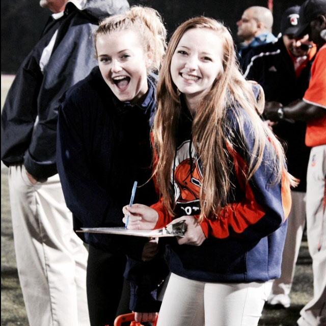 Managers Anna Bonavita and Hannah Keine pose for a picture at a 2014 football game. The managers dedictae their afternoons and Friday nights to the team.