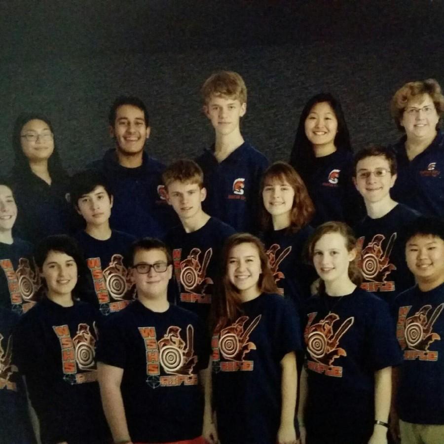 Photo of entire rifle team for the 2015-2016 school year wearing their team shirts along with coaches by their sidescoaches on the sides.