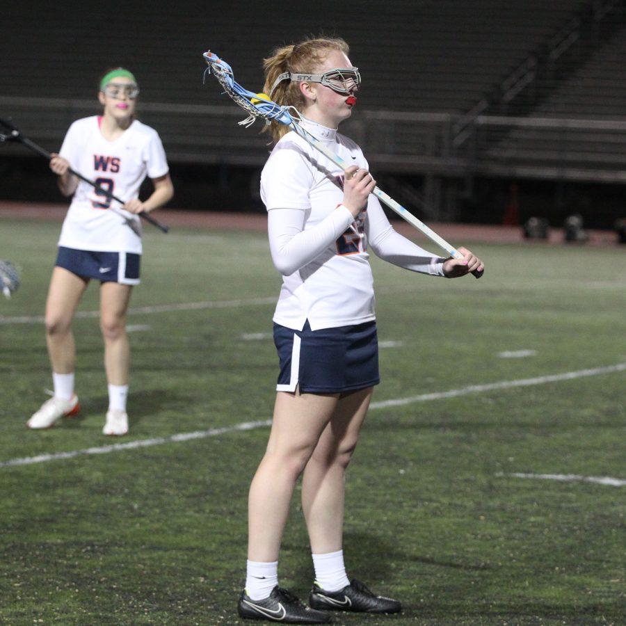 Senior Emma Sharman warming up with her varsity teammates for a game during last years spring lacrosse season. 