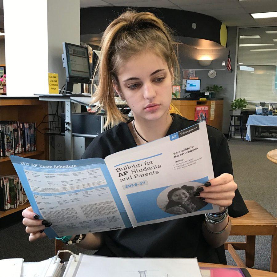 Senior Elise Roberts reads over the Bulletin for AP Students and Parents. It contains essential information such as what to expect, the 2017 testing schedule, and what to bring to for testing.