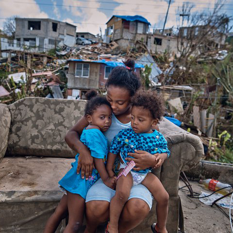 A mother embraces her two daughters in the middle of complete destruction as a result of Hurricane Maria. 