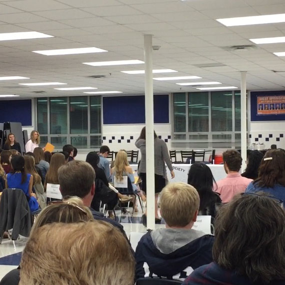 Family members and peers look as the induction ceremony takes place in the new cafeteria.