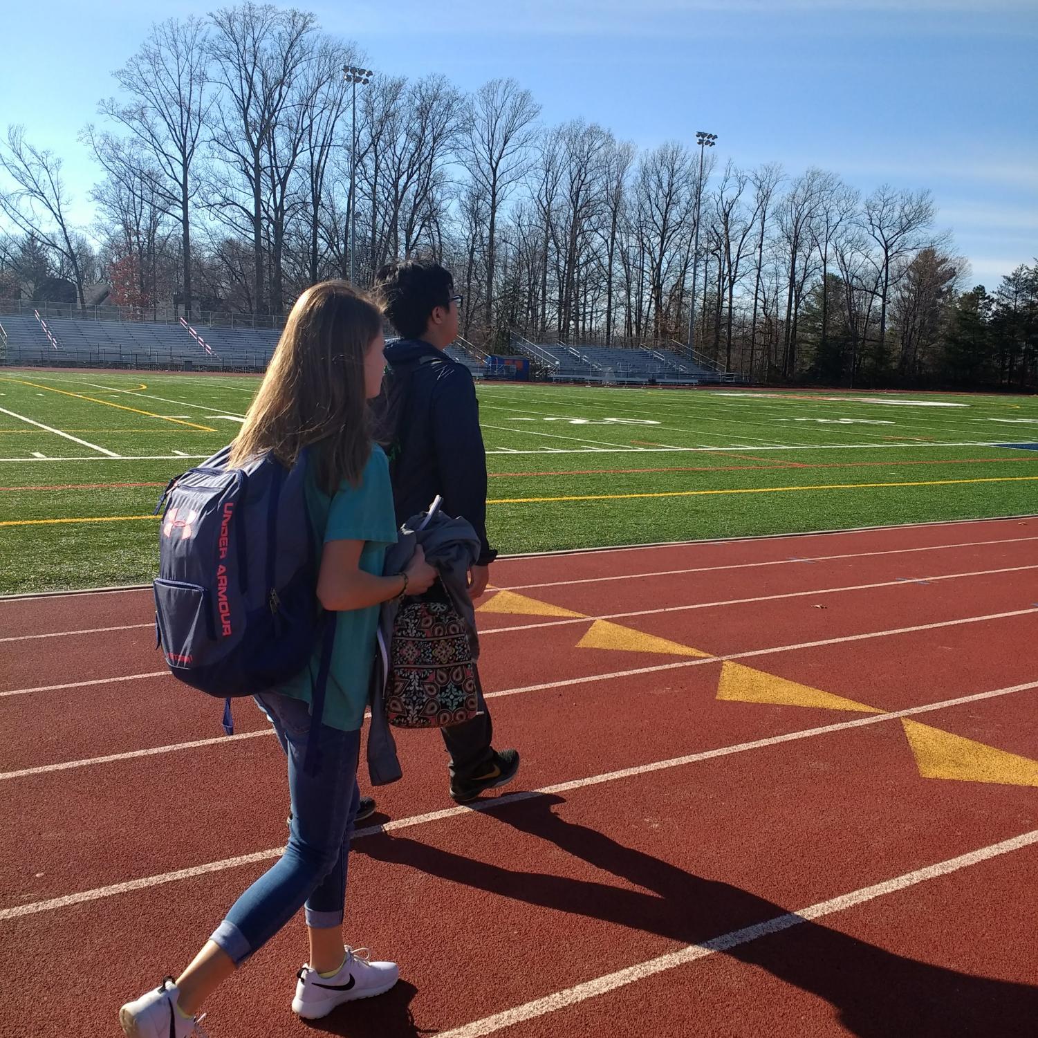 Students walk across the field in order to get to class. New studies have raised questions regarding the safety of these fields.