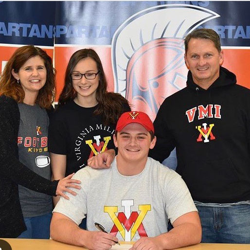 Senior Nick Hartnett poses with his family after earning a football scholarship to the Virginia Military Institute (VMI). Hartnett is an example of a hardworking athlete who was rewarded after succeeding both in school and on the field. This balance is critically important. 