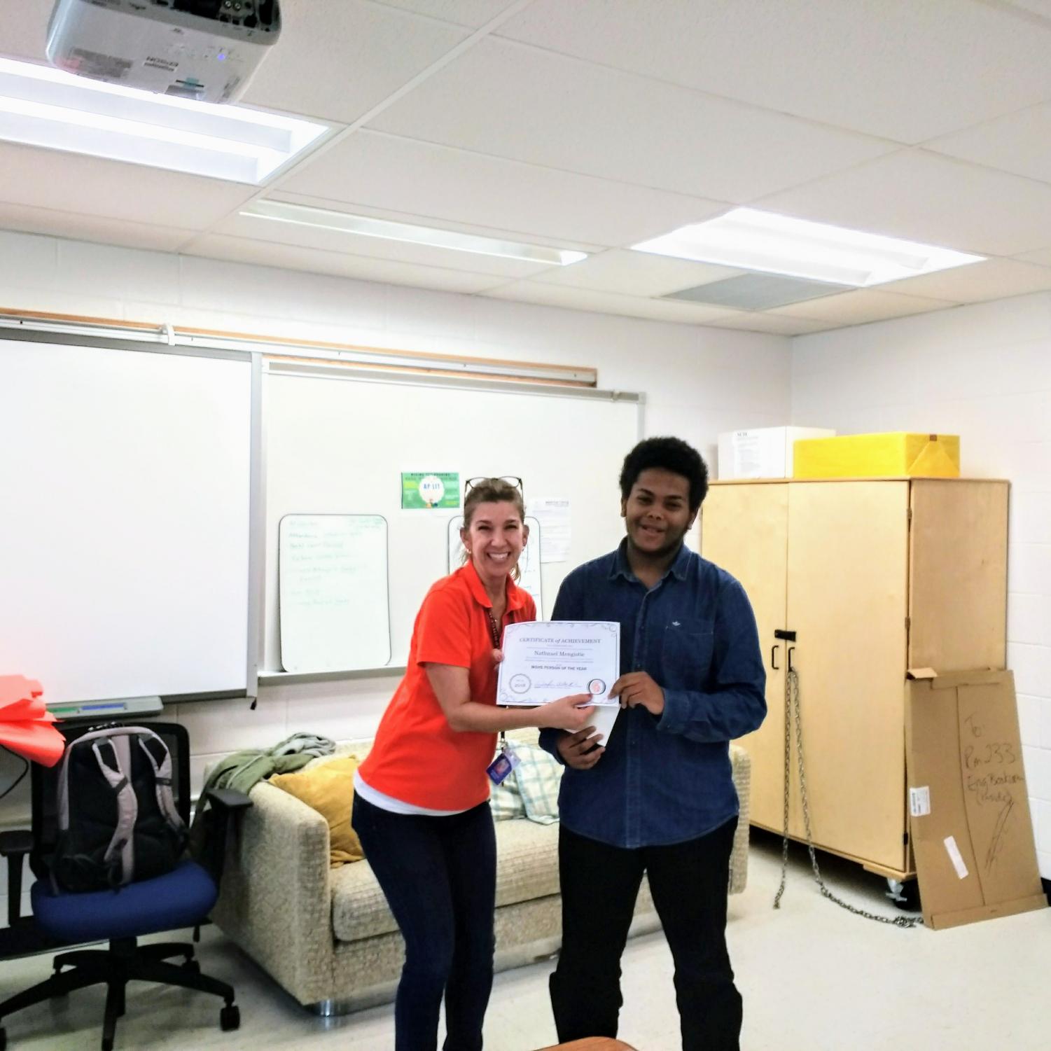 Nathnanael Mengistie holds a certificate honoring him and poses for a photo with Oracle advisor Jenifer Beach at the Person of the Year ceremony.