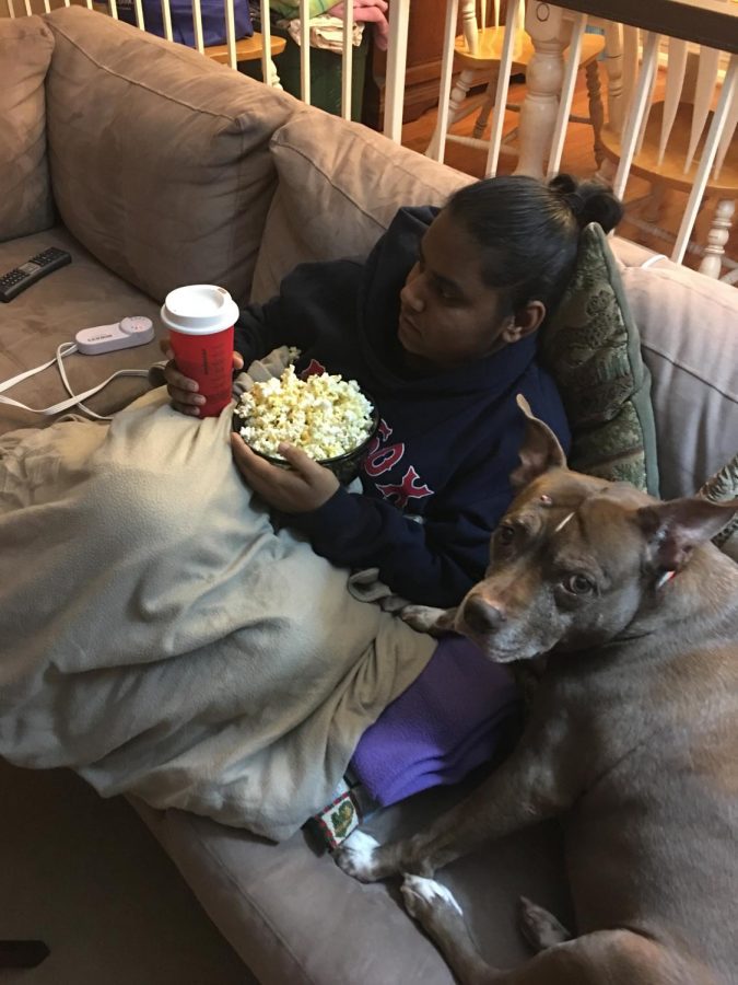 Senior Elina Vancini cuddles with her dog and a bowl of popcorn ready to enjoy a holiday movie marathon. There are a variety of movies for students to enjoy beyond the classics.
