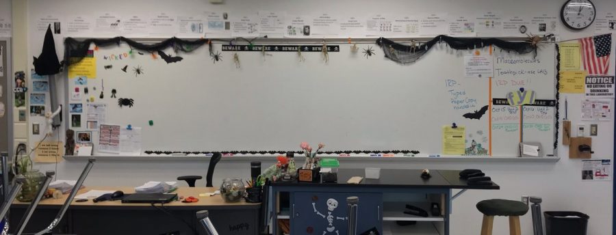 Teacher+Tammy+Riggins+shows+her+Halloween+spirit+by+decorating+her+board+with+dark+curtains%2C+spiders%2C+skeletons%2C+bats%2C+witches+hats%2C+and+a+sticker+saying+Beware.+