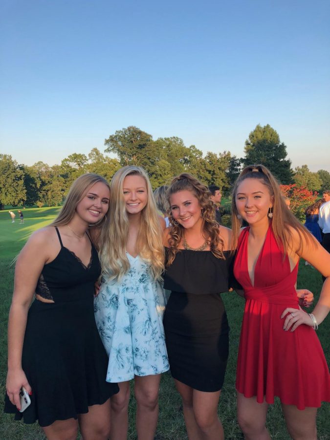 Juniors Lauren Basham, Caroline Guge, and Maeve Hennessy pose with former Spartan Annie Krompecher for a photo at the Springfield Country Club before the Homecoming dance.