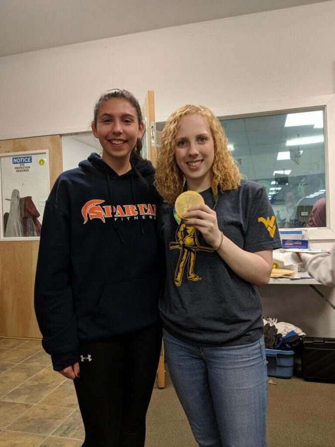 Freshman Mya Dickerson takes a photo with gold medalist Ginny Thrasher and her medal at rifle practice. Thrashers medal was the first won in the 2016 Summer Olympics.