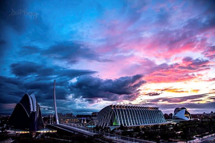 This is a view from the balcony of an apartment in Valencia, Spain. The balcony overlooks the iconic buildings in the City of Arts and Sciences Park. The colors of the sunset showcase the beauty this world has to offer.