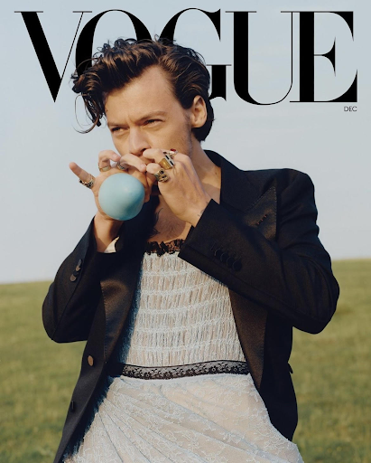 Harry Styles on the cover of Vogue’s December 2020 issue, styling a lace blue dress and holding a blue balloon.