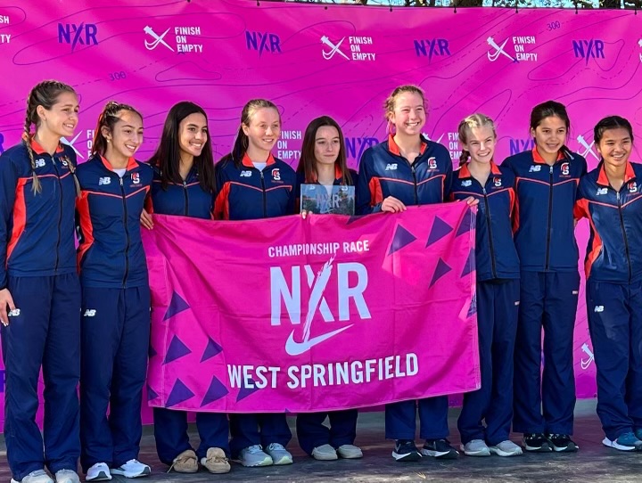 The Girls Cross Country team posing together for a group photo after competing at the Nike Cross Regionals (NXR). After sweeping first place at Districts and Regionals, they finished third at States and finished third in an unusually small field of 10 teams at NXR.