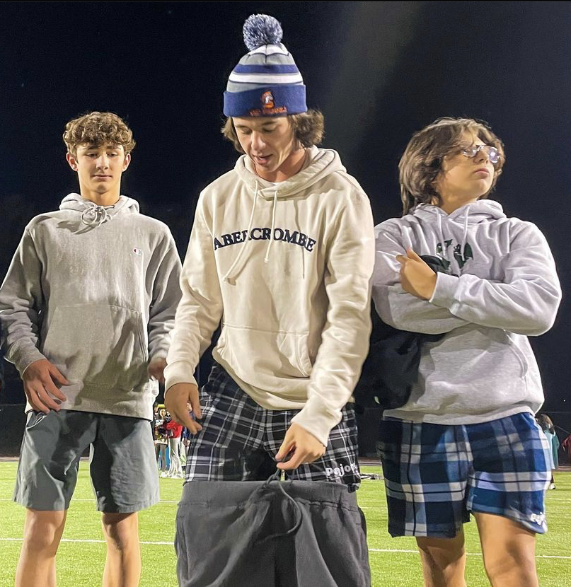 Pajort+brand+ambassadors+sophomores+Jon+Hennigh%2C+JP+Ogden%2C+and+Stephen+Zarbo+pose+in+Pajorts+for+the+Pajort_Instagram+on+the+football+field.