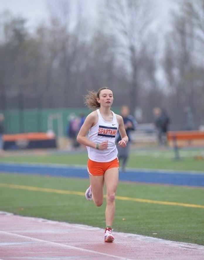 Sophomore Aidan MacGrath competing in the 3200 meter run. She finished first with a personal-best time of 10:54.05 and qualified for States.