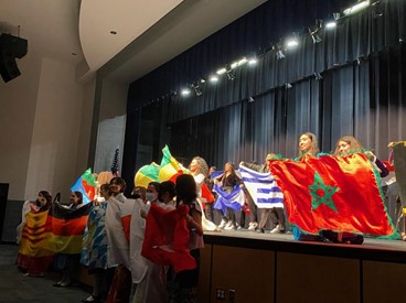 At the end of the show, students came together holding up flags from the countries they represented. The school community includes students coming from 79 different countries.