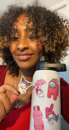 Senior Solyana Kumlachew poses with her water bottle that is adorned with stickers of Sanrio character My Melody. She is also holding a Kuromi sticker as well.