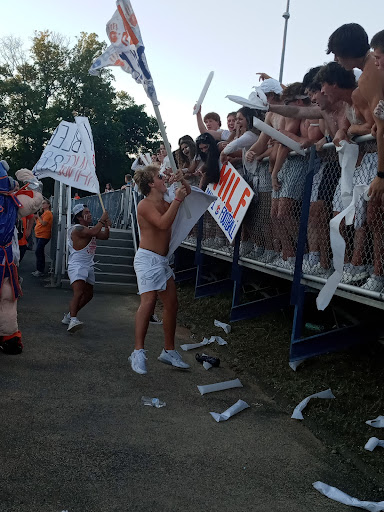 Senior Luke Baird hyping up the student section at the first home football game of the season against Thomas Edison High School.