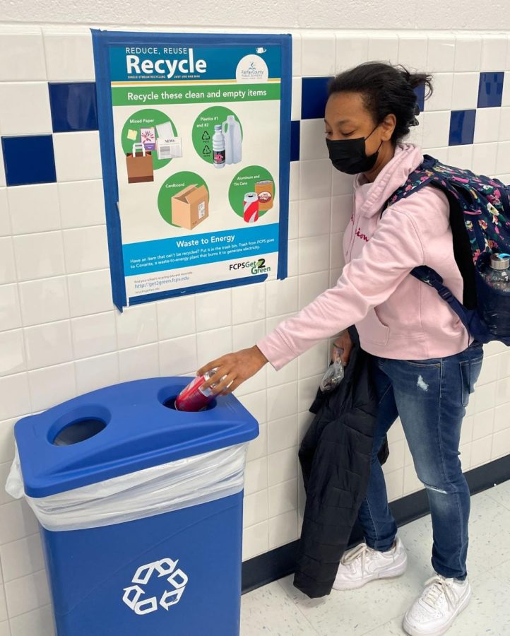 Senior+Bryer+Haywood+recycles+a+can+in+front+of+an+FCPS+%E2%80%9CGet2Green%E2%80%9D+poster.+As+seen+in+the+poster%2C+our+school+does+not+recycle+glass.+Fairfax+County%2C+as+a+whole%2C+however%2C+does+recycle+glass.+The+nearest+glass+recycling+location+is+the+Springfield+District+Governmental+Center%2C+which+is+a+short+three+minute+drive+from+campus.