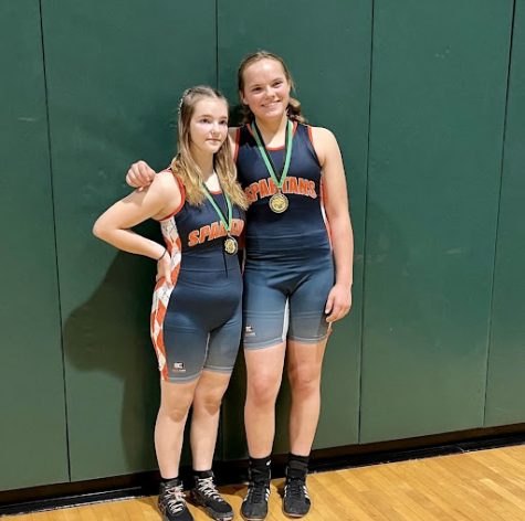 Freshmen Avana Harford (left) and Elaina Primozic (right) pose for pictures after each winning a gold medal at the 2022 Vic Blue Memorial Wrestling Tournament at Wakefield High School.