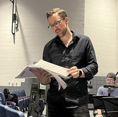 Brandt reading music during a pit orchestra rehearsal for the spring musical “Something Rotten!” as part of his many after-school duties.