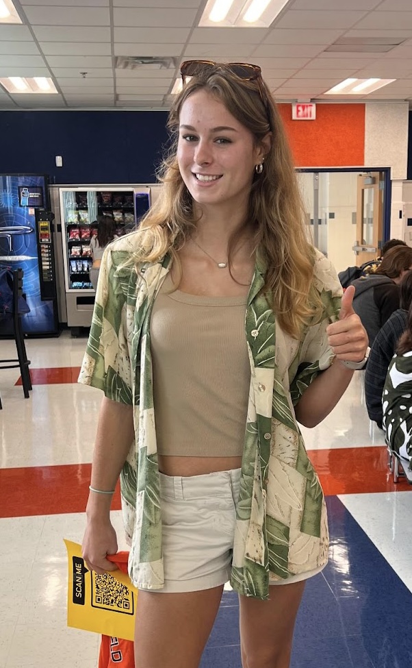 Junior and member of Student Leadership Hannah Luger passes out Homecoming T-Shirts and encourages the student body to vote for Homecoming Royalty with a QR code.
