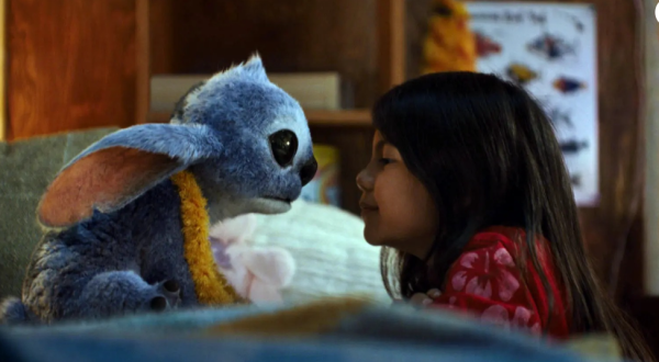 Lilo played by Maia Kealoha sits face to face with Stitch, voiced by Chris Sanders.