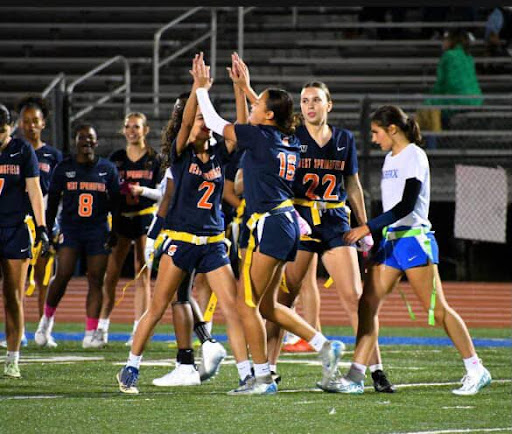 Flag football teammates share a moment of triumph following a key play late in the game.